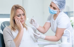 Patient with tooth pain being seen by a dentist